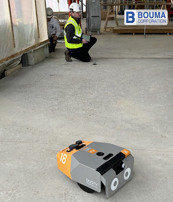 A bouma corporation construction worker uses the Dustry Robotics field printer to create an accurate, full-scale floor layout. 